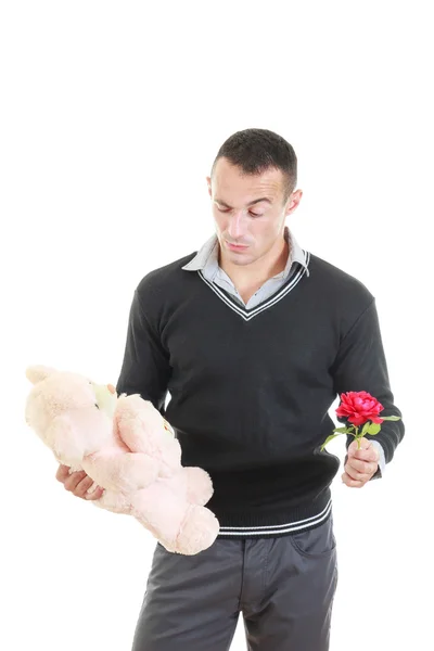 Hombre romántico eligiendo entre flores y oso de peluche — Foto de Stock