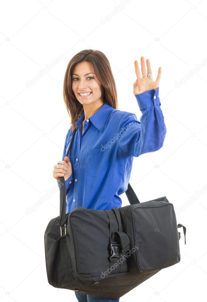 Pretty fashionable woman with large suitcase waving