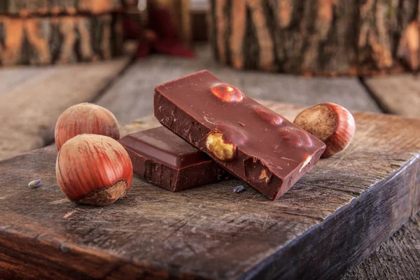 Chocolat aux noisettes sur planche de bois — Photo