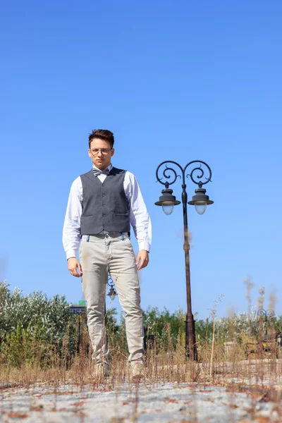 Hombre de camisa y chaleco con pajarita y gafas de pie — Foto de Stock