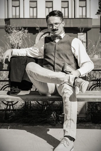 Man in suit with glasses and whiskers holding book in old town w — Stock Photo, Image