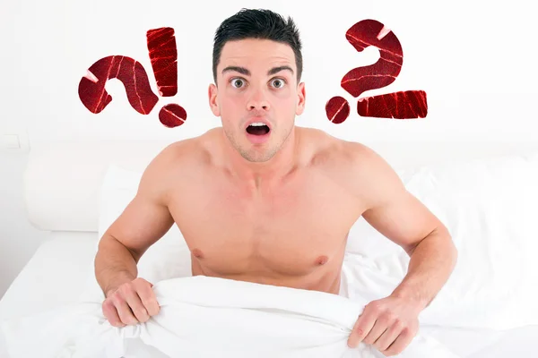 Shocked half naked young man in bed  looking down at his underwe — Stock Photo, Image