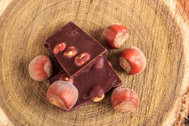 Çikolata ve fındık üzerinde üst görünümden ahşap güdük