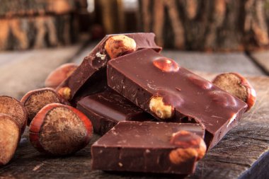 ahşap masa üzerinde fındık ile çikolata parçaları yığını