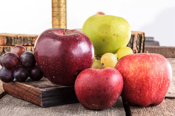 Manzanas y uvas sobre fondo de madera en composición doméstica —  Fotos de Stock