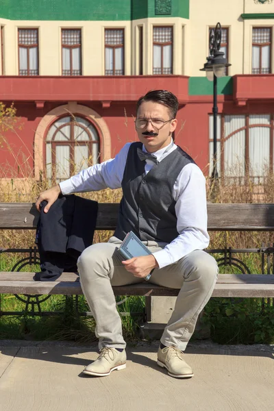 Empresario con un libro sentado en el banco —  Fotos de Stock