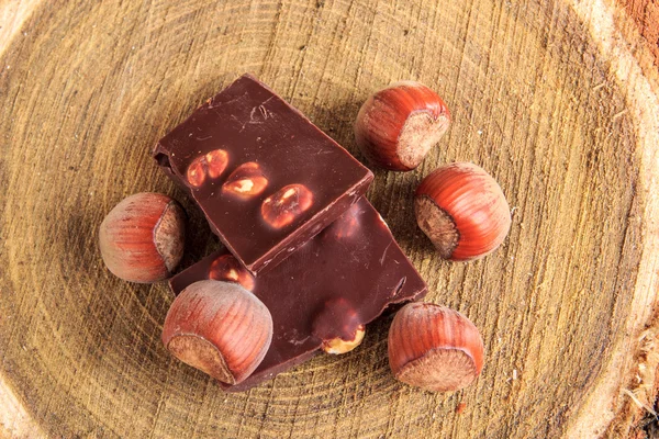 Çikolata ve fındık üzerinde üst görünümden ahşap güdük