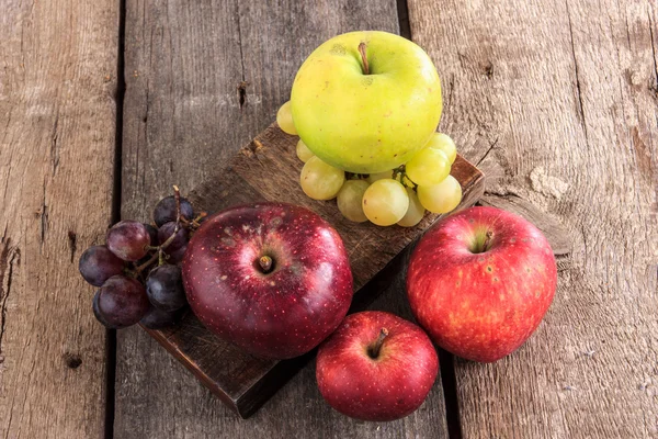 Frisches Bio-Obst, Äpfel und Trauben auf dem Holztisch — Stockfoto