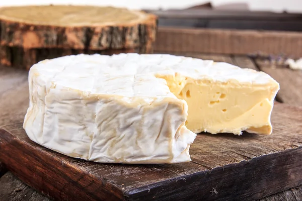 Roda de queijo redondo na placa de madeira — Fotografia de Stock
