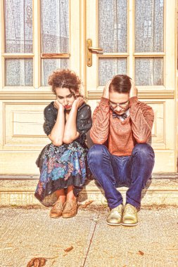 depressed and agitated man and woman crouching in front of the h clipart