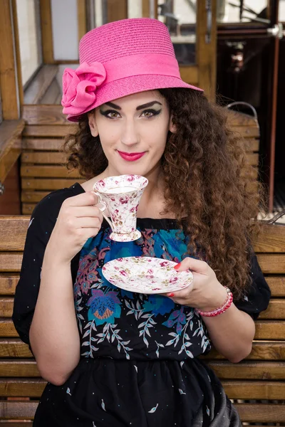 Leuk meisje in een karavaan zitten en drinken koffie of thee — Stockfoto