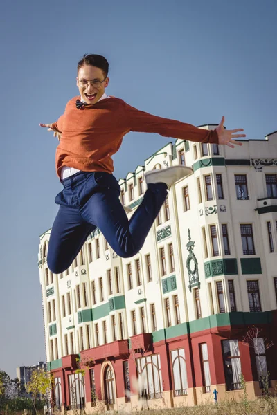 Casual man jumps hight in air on trowalk in old city and looki — стоковое фото