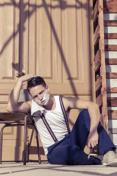 Hombre guapo con espuma de afeitar en su cara y toalla alrededor de su —  Fotos de Stock