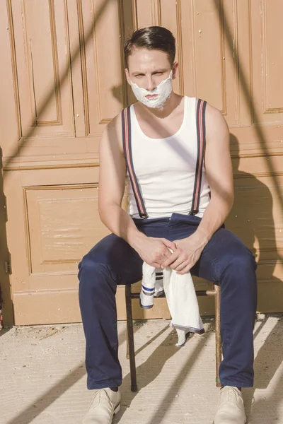 Hombre guapo con espuma de afeitar en su cara y toalla alrededor de su —  Fotos de Stock