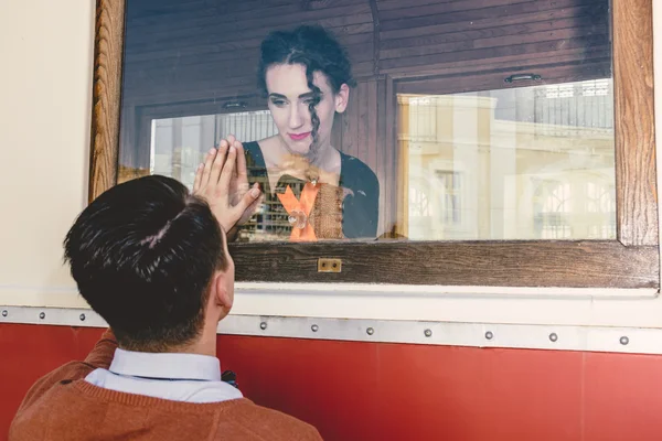 Bilden av sorgliga unga kvinna vinka i vagn tåg eller spårvagn Royaltyfria Stockfoton