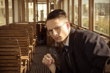 Takım elbiseli bir eski ahşap konvoy içinde oturan gözlüklü adam 