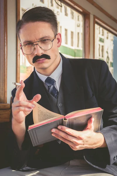 Homem com óculos e bigodes em terno sentado em uma velha madeira — Fotografia de Stock