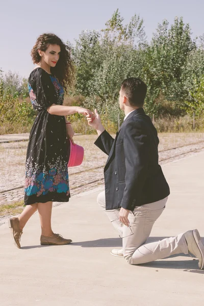 Retro vintage joven arrodillado y pidiendo a una chica a casarse con él — Foto de Stock