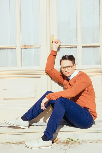 Poważne przystojny mężczyzna okulary i sweter siedząc na schodach i — Zdjęcie stockowe