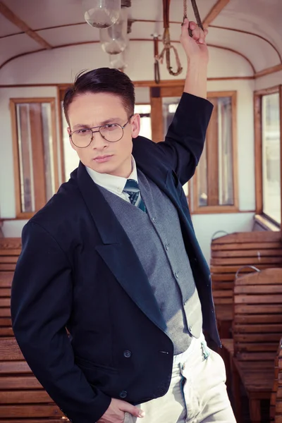 Hombre serio en traje con gafas posando y de pie en una vieja t —  Fotos de Stock