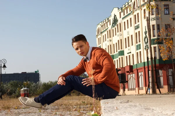 Jonge knappe casual man zit op de stoep in de oude stad een — Stockfoto