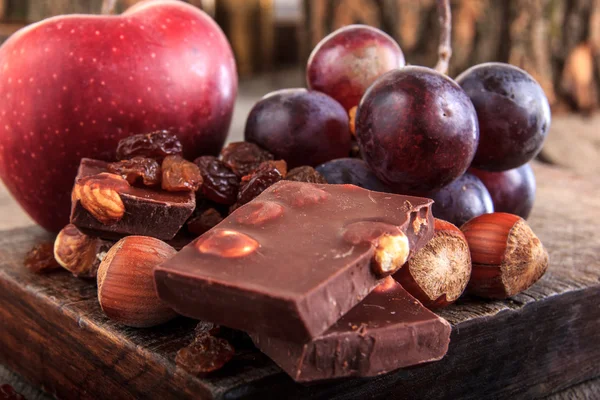 Chocoladestukjes met noten druiven en apple — Stockfoto