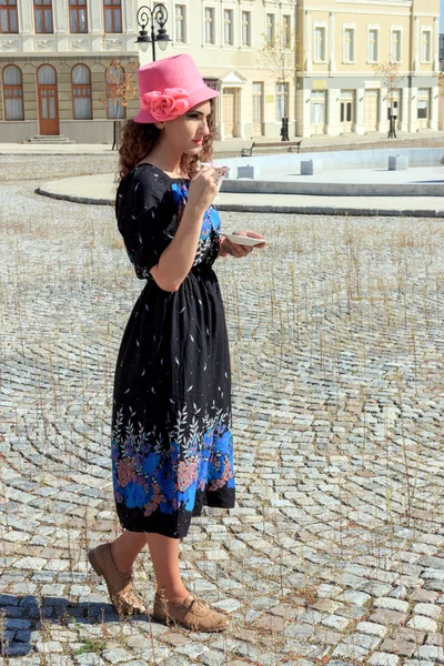 Mooie vrouw in retro jurk en hoed drinken warme drank of bever — Stockfoto