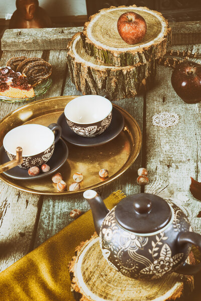 Tea cups with teapot on traditional vintage wooden table