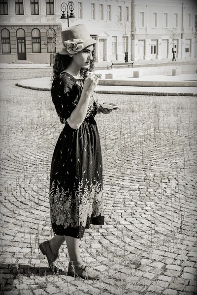 Frau in Retro-Kleid und Hut trinkt Heißgetränk — Stockfoto