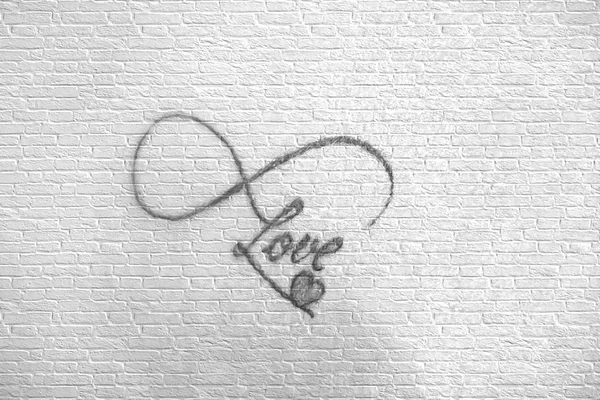 Foto de tatuaje abstracto en la pared de ladrillo que dice amor con smal — Foto de Stock