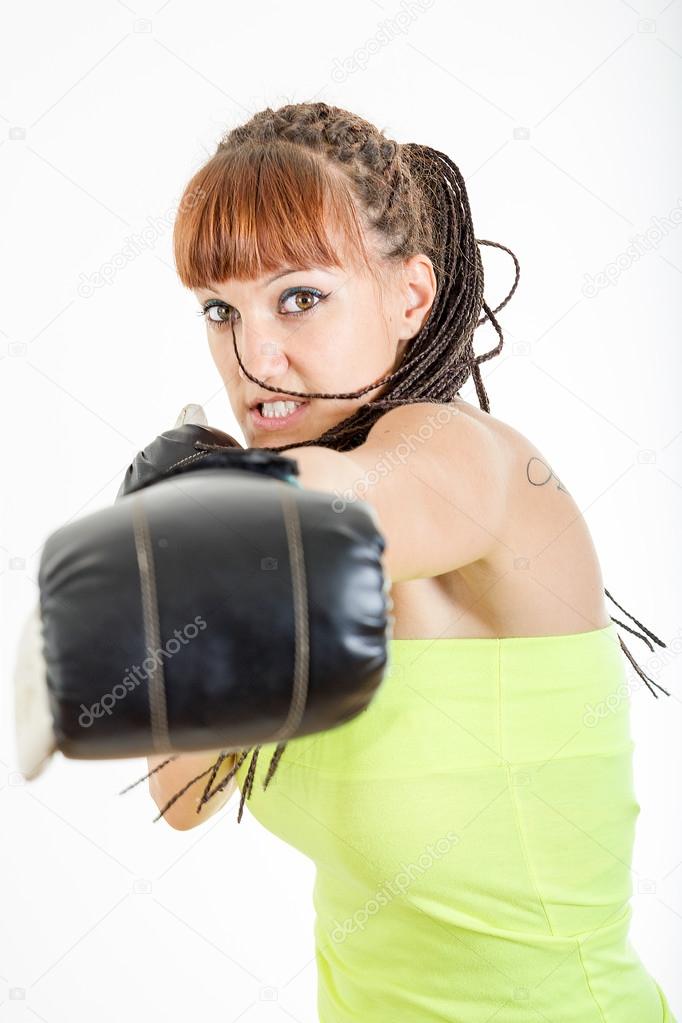 girl in rage wearing boxing gloves ready to fight and punching o