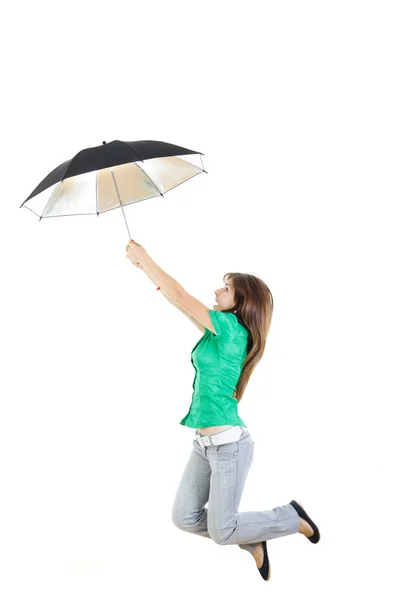 Girl in green shirt and gray jeans pants with umbrella jumping — Stock Photo, Image