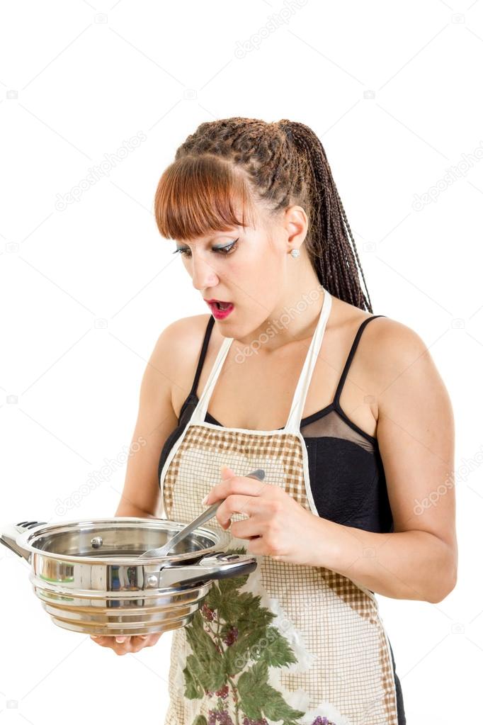 Surprised woman in the kitchen stirring the pot