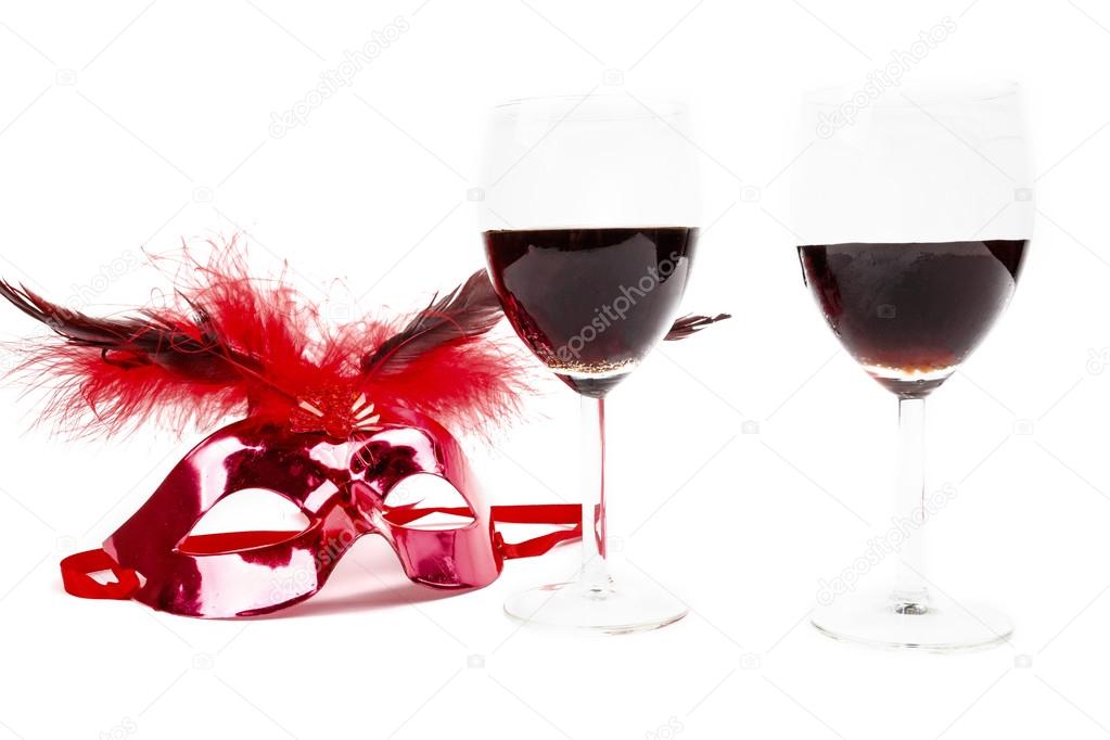 glasses of wine with one glamorous red mask isolated on white