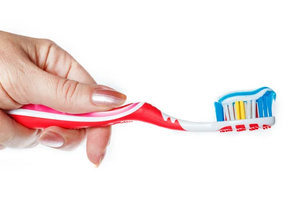 Mão segurando escova de dentes vermelha com pasta de dentes azul de duas cores no li — Fotografia de Stock