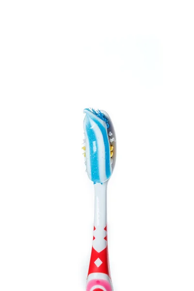 Cepillo de dientes con pasta de dientes azul de dos colores en la superficie ligera —  Fotos de Stock