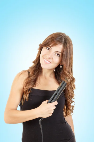 Young woman using curly iron on her hair — Stock Photo, Image