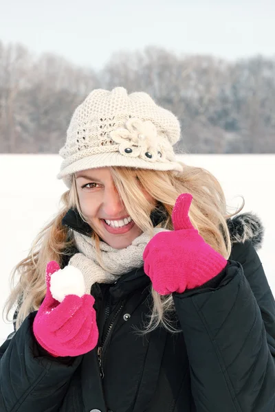 Mujer feliz en la nieve sosteniendo la bola de nieve en la mano para bolas de nieve —  Fotos de Stock