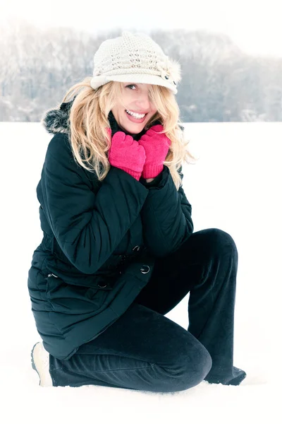 Happy woman in snow looking up at camera outside — Stock Photo, Image