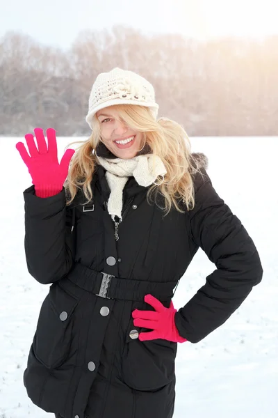 Invierno feliz mujer en la nieve mirando hacia arriba a la cámara y saludando —  Fotos de Stock