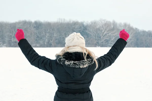 Winter woman in snow showing her back and facing forest — Stock Photo, Image
