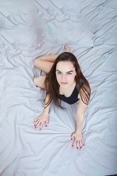 Young  passionate woman or girl lying on bed in seductive pose — Stock Photo, Image