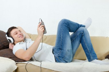 genç adam zevk müzik kulaklık ve cep telefonu ile gülümseyen