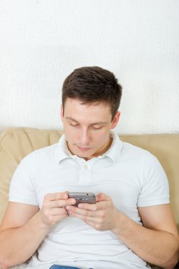 Genç adam cep telefonunu kullanıyor.