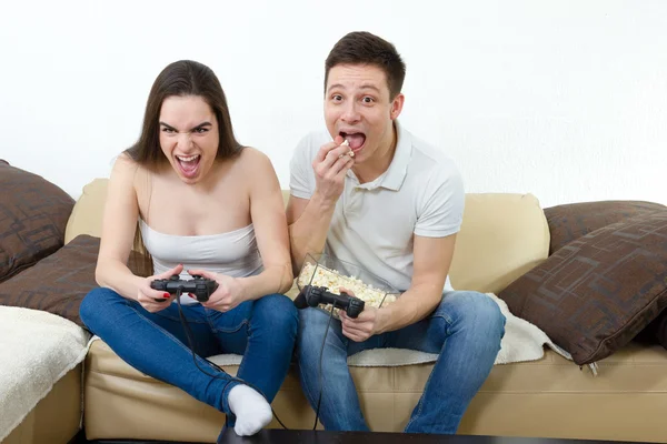 Couple in love on sofa sitting and playing video games in living — Stock Photo, Image