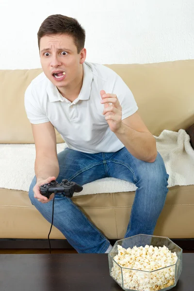 Guy mangiare popcorn con joystick per console di gioco — Foto Stock