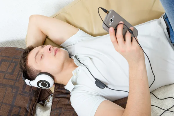 Man fall asleep listening to music over smartphone with headphon — Stock Photo, Image
