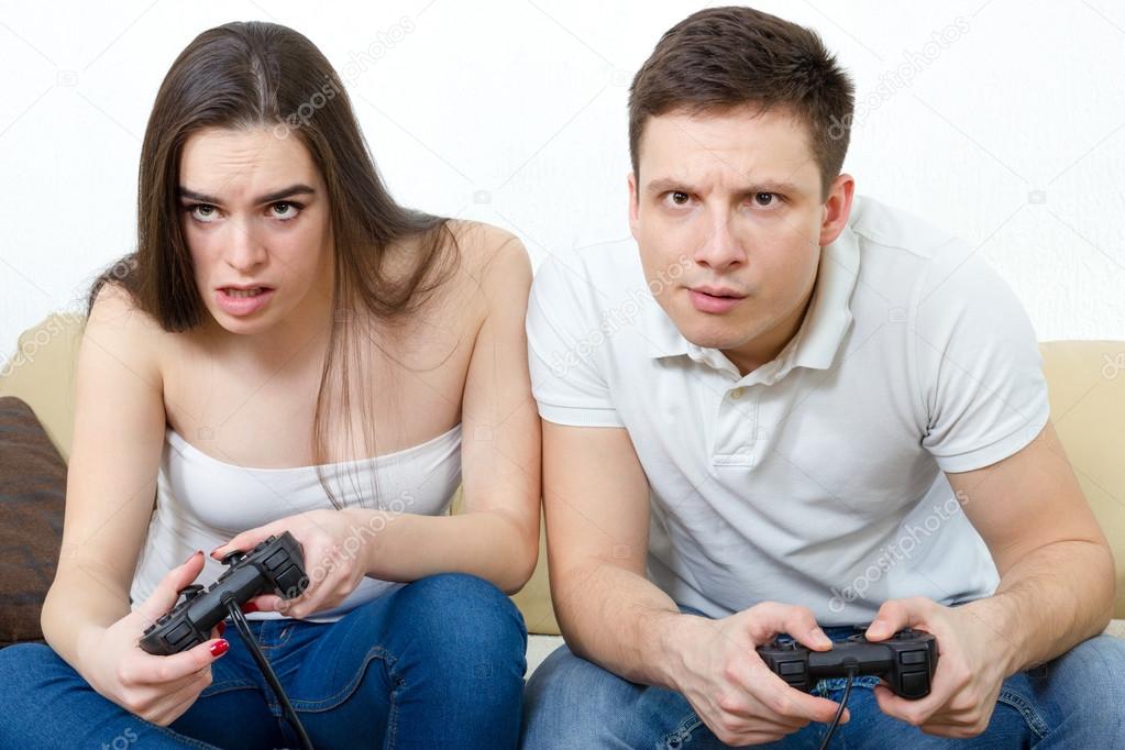  couple sitting in living room and play video games on console o