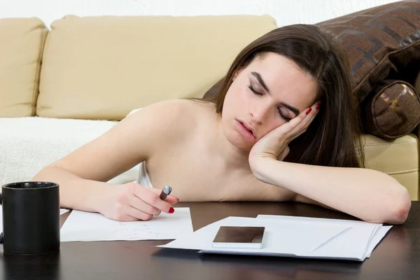 Student moe en slapen in haar woonkamer boven de aantekeningen. — Stockfoto