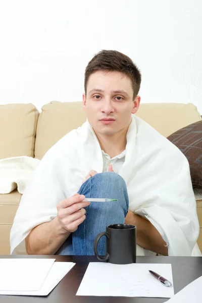 Ill male student  having headache covered with white blanket. — Stock Photo, Image